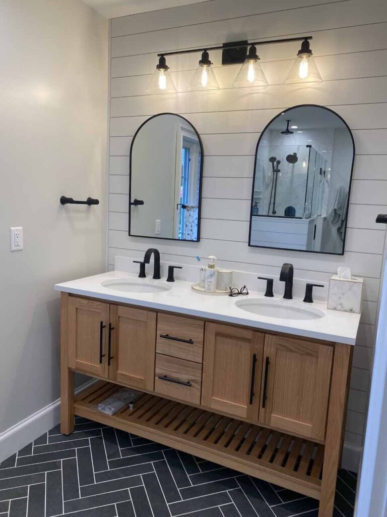 light brown bathroom vanity with black hardware and black bathroom faucets