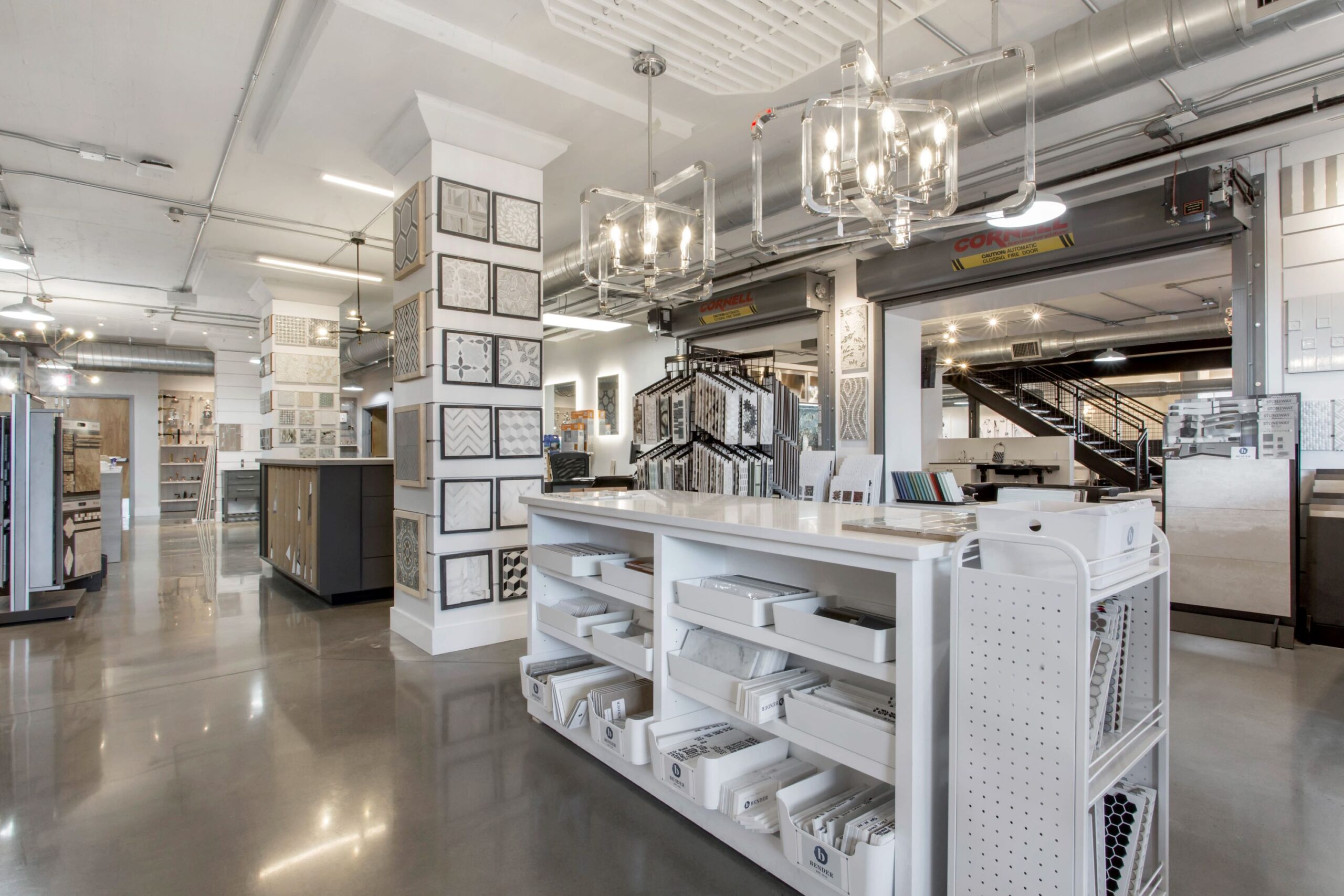 white island, tile displays, white shelves, hanging light fixtures, showroom displays, concrete floor