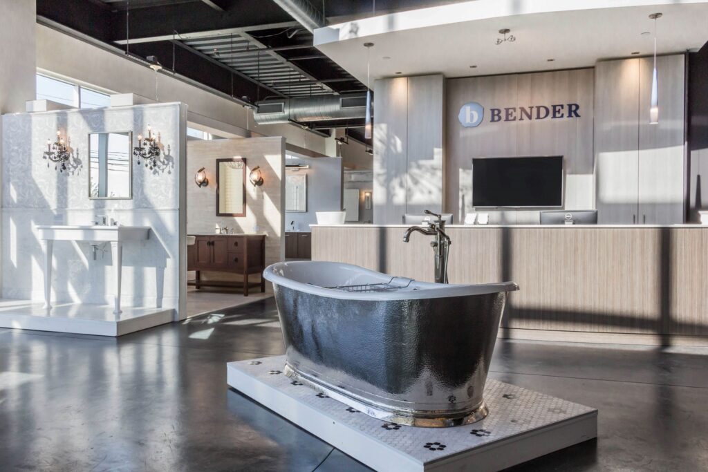 Bender shoroom, dark bathtub, bathroom displays, front desk, flat screen television, lighting display, concrete floor