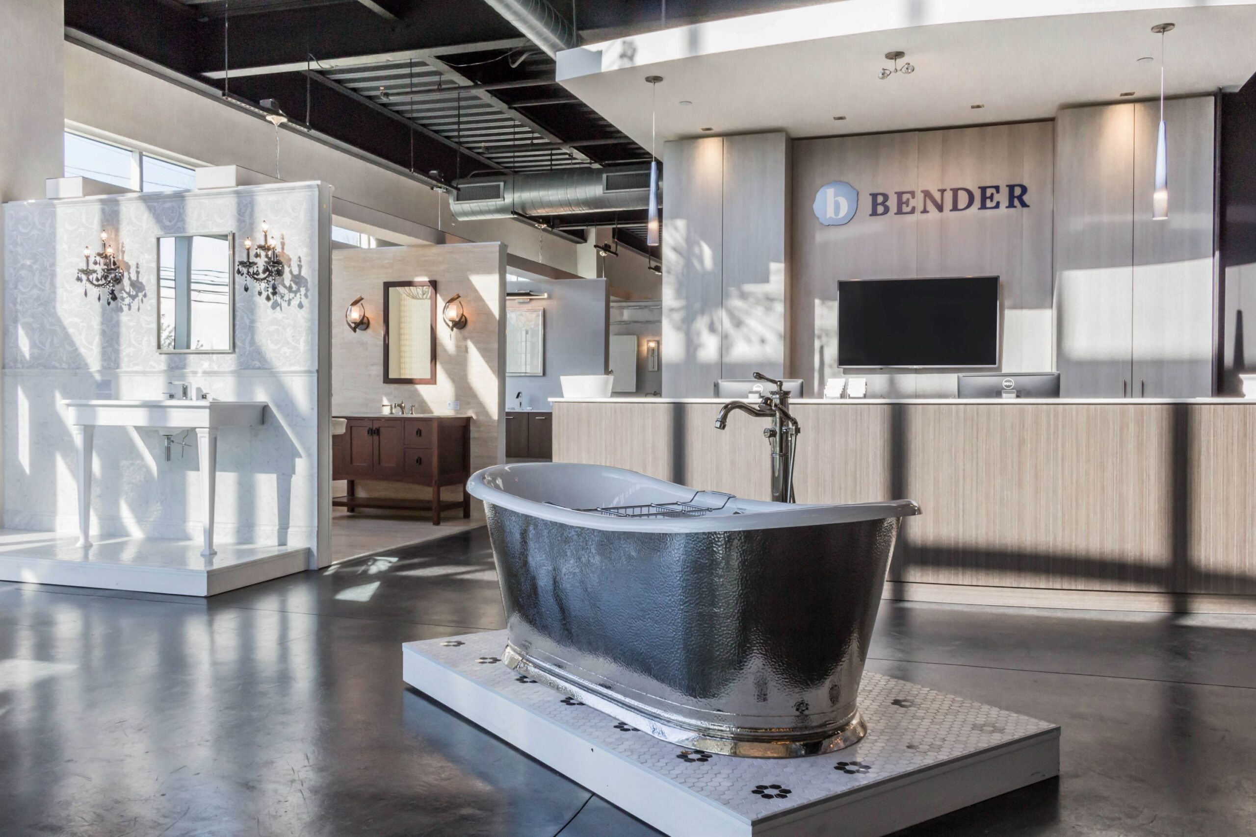 Bender shoroom, dark bathtub, bathroom displays, front desk, flat screen television, lighting display, concrete floor