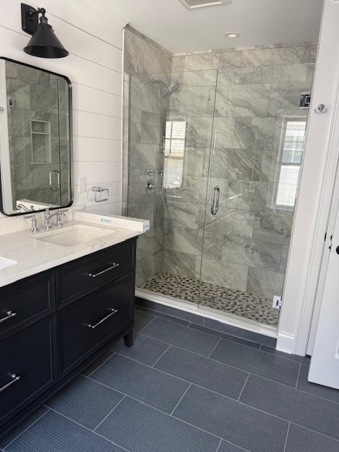 black vanity, farmhouse light and mirror, marble tile