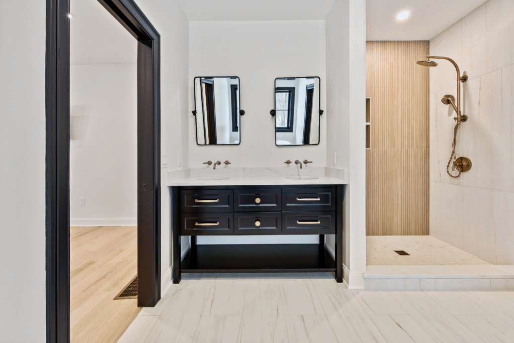 black vanity walk in shower with wood accent and brushed bronze fixtures