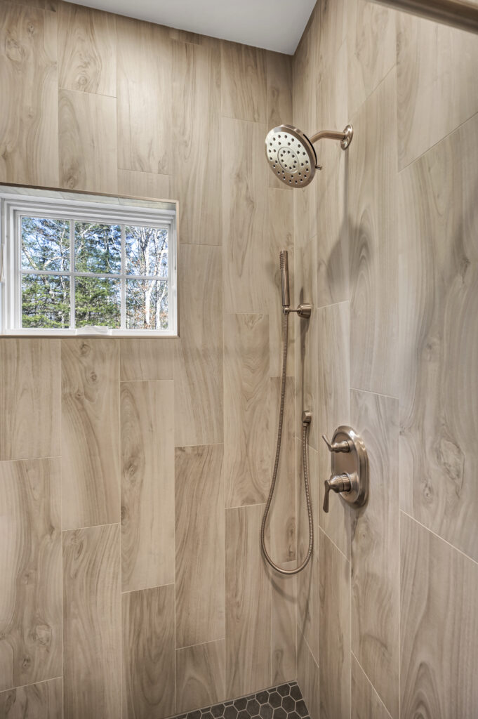 brown tile shower with gold accents