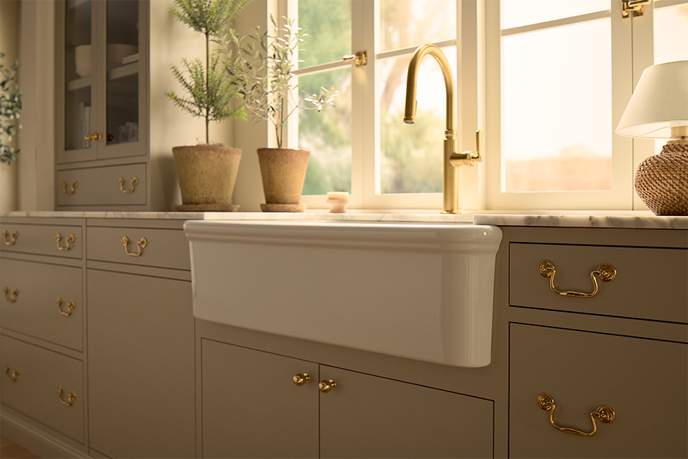 white farm sink with gold faucet